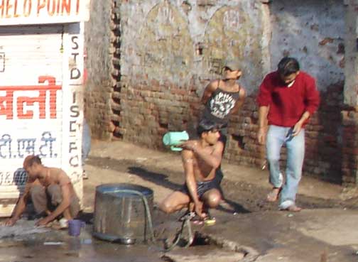 Man washes his body at a pump.