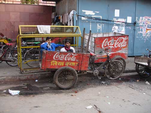 Coca Cola ad on the side of bicycle rickshaw.