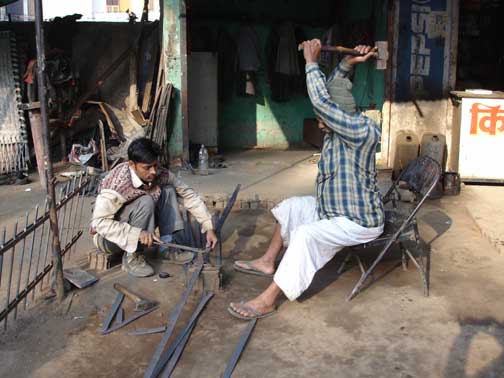 Man with sledgehammer cutting metal.