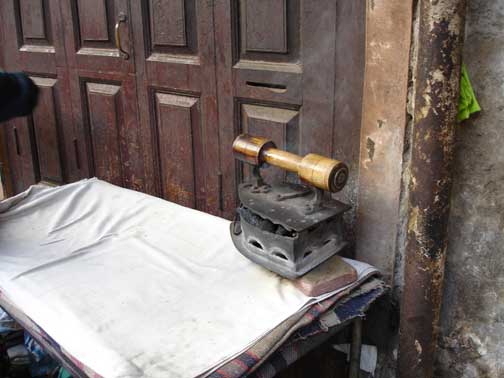 Coal iron heating up on ironing board.