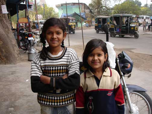 Two girls pose for a picture in the small town near the drugstore.