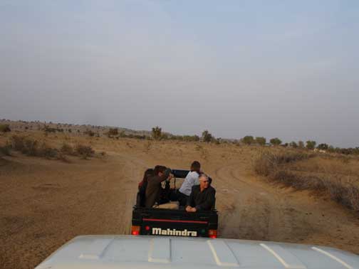 Benjamin and Robbie in back of jeep riding in desert to Manwar Camp.